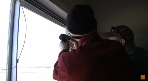 Screw the storm window frame into the existing window’s wood casing to secure it.
