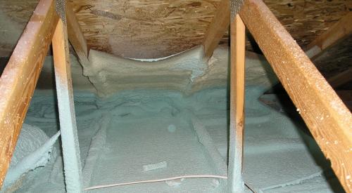 Spray foam insulates and air-seals the ceiling deck and top plates of this vented attic.