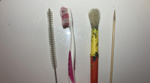 Implements used to clean debris from exhaust fan blades.