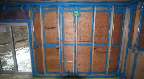 Sprayer-applied sealant seals every seam in the sheathing and framing of this double-walled home. 