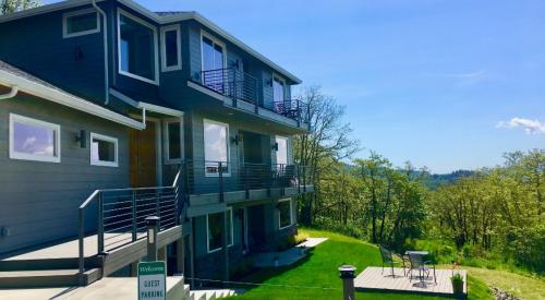 These wildfire-resistant decks have a solid decking surface, metal railings, and the underside timber supports are covered with flame-resistant fiber cement board; also the decking is set back from the vegetated slope. 