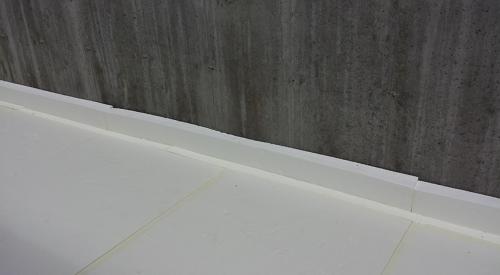 Four inches of rigid foam separate the concrete slab from the ground and the foundation walls. 