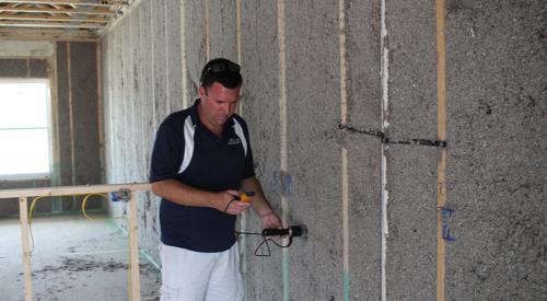 Moisture levels are checked in the blown cellulose insulation before enclosing the walls.
