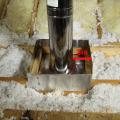 Right- This flue pipe has been air sealed with sheet metal and fire-rated caulk and an insulation dam has been constructed to keep insulation from touching the hot flue pipe