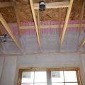 Spray foam insulates the top plates and air seals them to the ventilation baffles before ceiling drywall is installed.