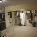 The mechanical room in the insulated basement houses the water heating equipment, including the storage tank for the solar thermal system and the wall-hung boiler as well as the air handler for the hydro coil and high-efficiency (16 SEER) air conditioner.