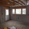 Drywall was removed and the existing 2x4 walls were filled with 3.5 inches of dense-packed cellulose. Outside, the ½-inch plywood was topped with house wrap, 1.5 inches closed-cell rigid foam, 1x3 furring strips, and fiber cement siding.