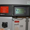 The photovoltaic system comes with a readout screen showing power production.