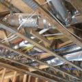 The ducts are located in conditioned space in open-web joists between the floors and supported to prevent sagging.