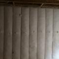Dense-packed blown fiberglass insulation completely fills the wall cavities with no gaps or voids.