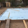 Rigid foam extends under the full slab and lines the inside edges of the foundation walls.