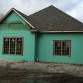 Two types of paint-on flashing (green and red) are installed on the walls and around the windows, over the coated sheathing which is taped at the seams.