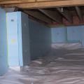 A vapor barrier was installed on the floor of this crawlspace and extended up the walls then the foundation walls were covered with rigid foam.