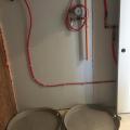 Right – Drip pans are installed beneath the home’s 55-gallon heat pump water heater desuperheater tank and back up electric tank water heater.