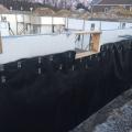 Right - A dimpled-plastic geotextile mat covers the below-grade insulated concrete form (ICF) foundation to help keep water out of the foundation and to reduce hydrostatic pressure on the foundation during freeze-thaw cycles in winter.