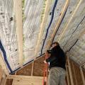 Horizontal furring strips are installed over a taped smart membrane that serves as an air and vapor barrier and holds in insulation; the furring strips will provide a nailing surface for tongue-and-groove wood porch ceiling cladding.