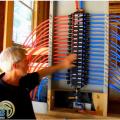 Right – A builder of a DOE Zero Energy Ready certified home explains how a central manifold distribution system with PEX piping works. 