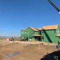 Right – This home’s above-grade walls are constructed in a factory where wall panels of 2x6 studs are assembled and sheathed with a coated OSB product, then windows are installed and flashed before shipping the panels to the site for assembly by crane. 