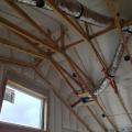 Right – R-23 of blown fiberglass fills the walls and unvented vaulted attic cavities of this marine-climate home while an additional R-20 (4-inches) of graphite-enhanced expanded polystyrene is installed above the roof sheathing.