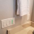 The green-lit panel next to the fan and light switches is an indoor air quality sensor that will automatically turn on the exhaust fan if it detects a rise in humidity or indoor air pollutants. 