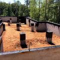 The top course of these concrete masonry unit (CMU) crawlspace foundation walls and piers is filled with grout then sprayed with a waterproofing membrane that acts as a capillary break and prevents moisture from migrating into the framing material.