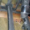 Sheet metal and mastic provide air sealing around a flue pipe. 