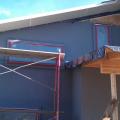 A liquid-applied water barrier covers the walls, serving as a drainage plane, air and vapor barrier, and secondary window flashing beneath the rigid foam that will be installed next.