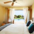 This room has several passive and low-energy cooling features including a ceiling fan, fully operable French doors, window shading, an outdoor water feature, and light-colored hard-scaping.