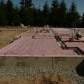 An ultra-efficient layer of R-20 rigid foam foundation insulation covers the ground underneath the vapor barrier and radiant floor loops, which will circulate water heated by an ultra-efficient geo heat pump. 