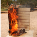 The combustible siding product on the left side in this demonstration burns readily when exposed to a burning wood sample, while the noncombustible siding on the right does not ignite