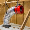 Modern ducted whole-house fans are suspended from roof framing and connected to the intake grille by a curved acoustic duct, greatly reducing vibration and noise in the occupied space.