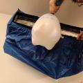 A foaming cleaner is used to clean the coils inside this ductless indoor unit; a mini-split bib surrounds the unit to contain overspray and drips