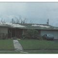 Failure of extruded concrete flat tile roofing due to bond failure between tile, mortar, and underlayment resulting from hurricane force winds.