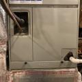 The filter access panel on this vertical upflow air handler is located between the return ductwork below and the coils above.