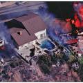 This house survived a wildfire due in part to fire-resistant walls and roof while surrounding houses were destroyed (Photo from Decra Roofing Systems, Used With Permission). 