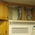 Install the fan either in the range hood, the cabinet above the stove, or on the wall above the stove