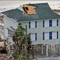 High winds pulled the asphalt shingles and sheathing panels off this coastal home, although storm shutters protected the windows