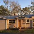 This home uses light-colored standard paints and finishes on siding and roofing materials to reduce cooling loads without adding material cost.