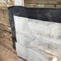 Right - The service penetration in the waterproofing membrane is well-sealed, and there is a drainage mat acting as a protective layer on the interior of the soldier piles and wood lagging. 