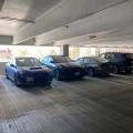 Mechanical exhaust is not required in this shared parking garage in a multistory multifamily building because the garage is not enclosed and can rely on natural air changes to reduce airborne contaminant concentration.