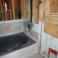 Gypsum board is installed behind the bathtub before the tub is installed and all seams are sealed