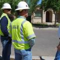 A builder meets with utility staff at a job site.