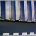 Right – This metal panel window shutter is installed in a track permanently mounted above and below the window frame and is secured with wing nuts to studs mounted on the track. 