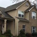 Wrong - Missing kick-out flashing to divert rainwater runoff away from the house and into the gutter where the roof meets the wall has caused discoloration of the stucco and water damage behind the stucco by the front porch and the second-story window. 
