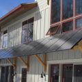 The photovoltaic solar panels installed on the south face of this home perform double duty as window overhangs for summertime shading.