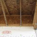 Framing is sequenced to install an air barrier of OSB, plywood, or rigid foam between the porch and the attic.