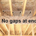 Gaps between garage and conditioned space are properly sealed by carefully cutting and then caulking wood sections to fit between trusses above shared walls.