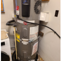 Right: This heat pump water heater is installed in a laundry room with enough space for the control panel and vents to be clear of obstructions; The HPWH can use heat from the dryer to heat water, but the seismic straps should be lower