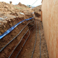 Foundation heat exchanger installed in overcut around a basement wall