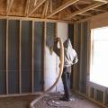 Blown fiberglass insulation fills netted wall cavities 